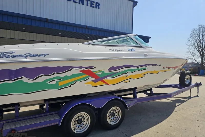 Slide: The Image of 2001 Powerquest 280 Silencer boat with colorful graphics on a trailer. - 7