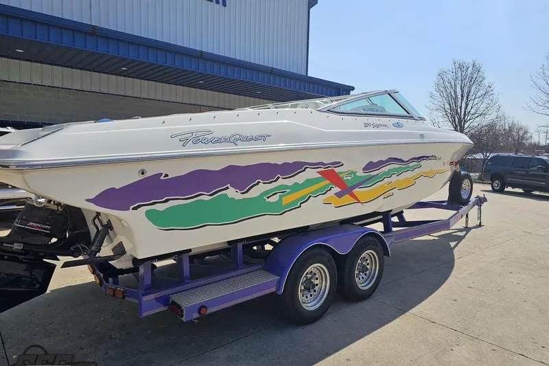 Slide: The Image of 2001 Powerquest 280 Silencer boat on trailer with colorful graphics, parked outdoors. - 8