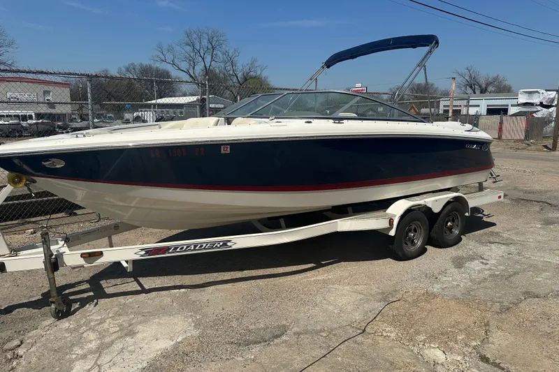 The Image of 2006 Cobalt 220S boat on trailer, parked outdoors under clear blue sky. - 1