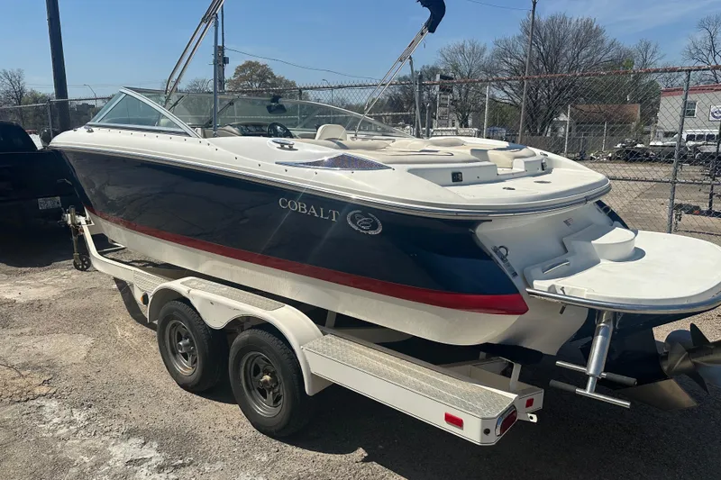 Slide: The Image of 2006 Cobalt 220S boat on trailer, parked outdoors, showcasing sleek design and dual axle trailer. - 11