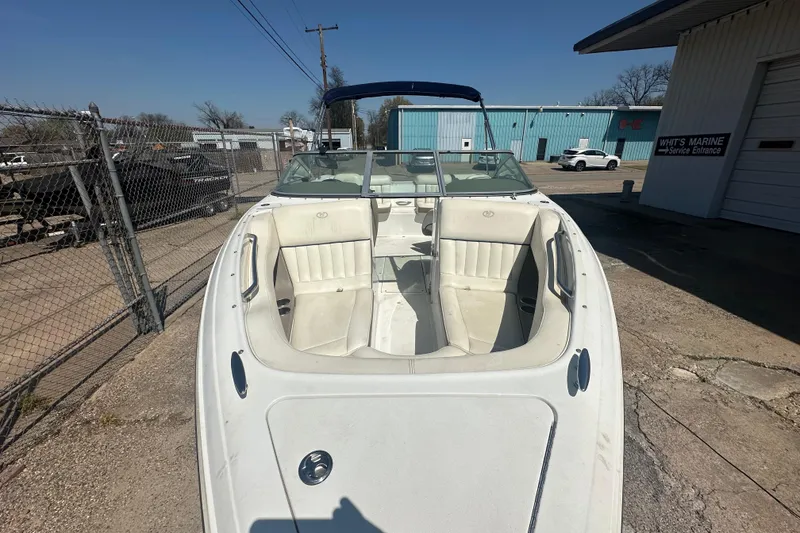 Slide: The Image of 2006 Cobalt 220S boat with white interior, parked outside a marine service center. - 16