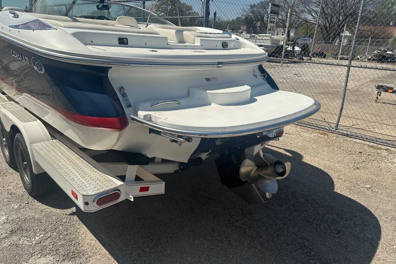 Slide: The Image of 2006 Cobalt 220S boat on trailer, rear view, parked near chain-link fence. - 18