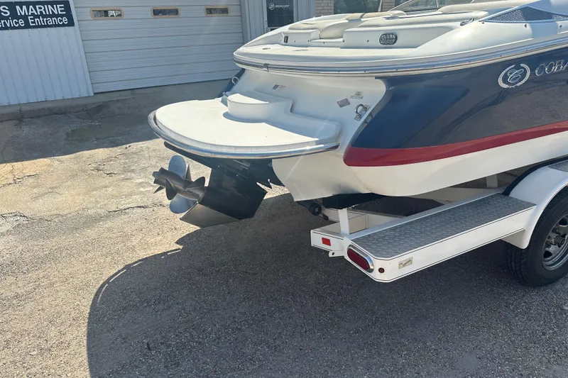 Slide: The Image of 2006 Cobalt 220S boat rear view with propeller and trailer at service entrance. - 20