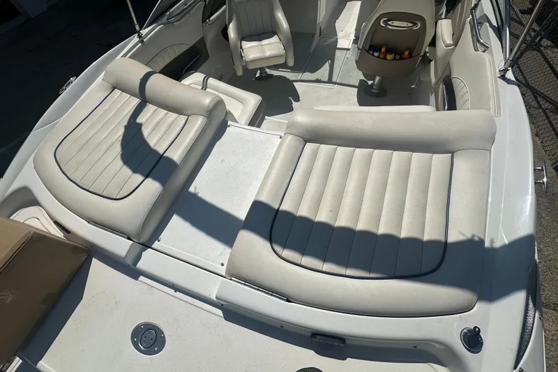 Slide: The Image of 2006 Cobalt 220S boat interior with white leather seating and storage compartments. - 21