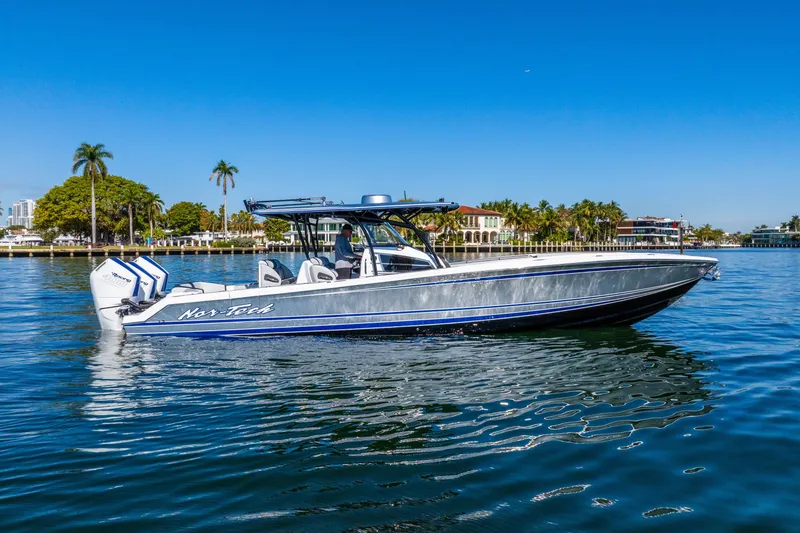 The Image of 2026 Nor-Tech 390 Sport Center Console boat cruising on a sunny day. - 1