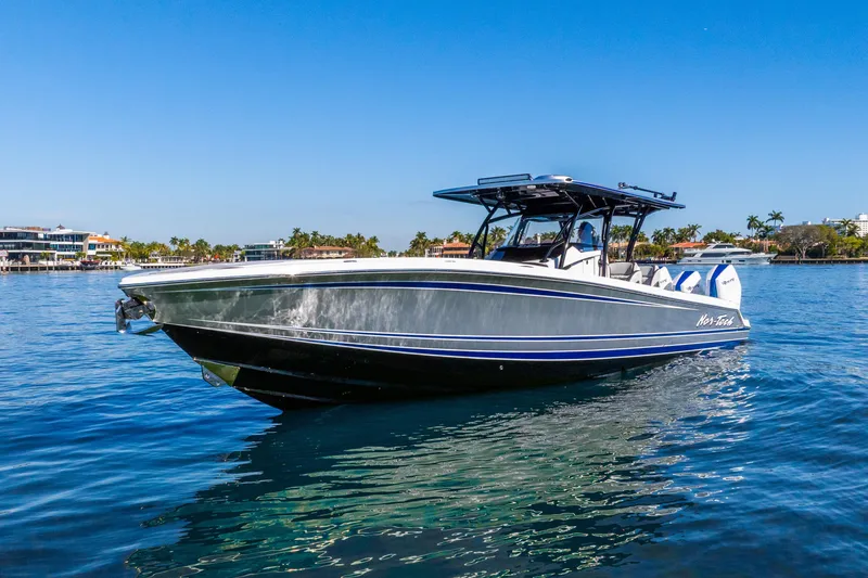 Slide: The Image of 2026 Nor-Tech 390 Sport Center Console boat on clear blue water. - 10