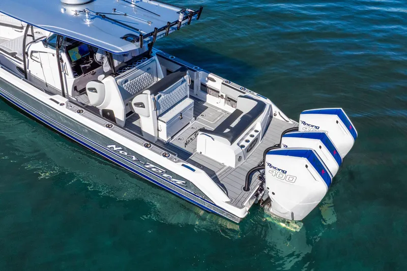 Slide: The Image of 2026 Nor-Tech 390 Sport Center Console boat with triple engines on clear water. - 12