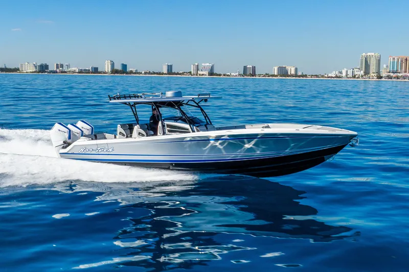 Slide: The Image of 2026 Nor-Tech 390 Sport Center Console cruising on blue ocean near city skyline. - 14