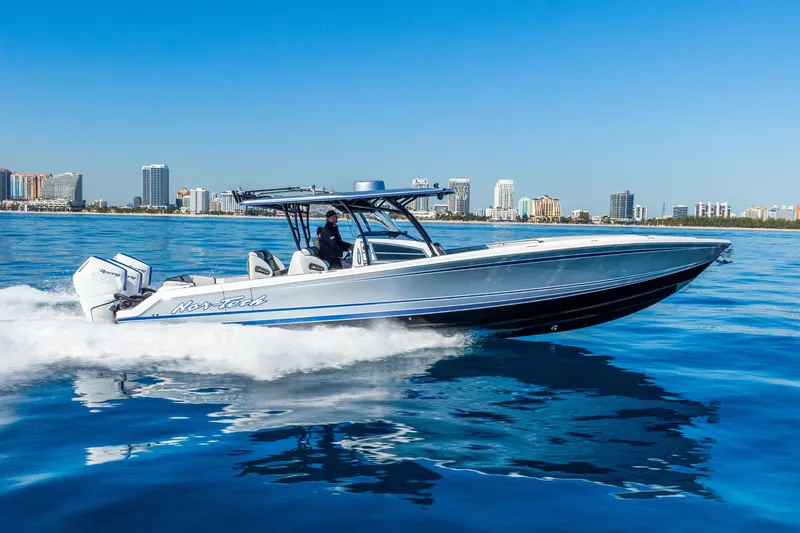 Slide: The Image of 2026 Nor-Tech 390 Sport Center Console cruising on blue water near city skyline. - 15
