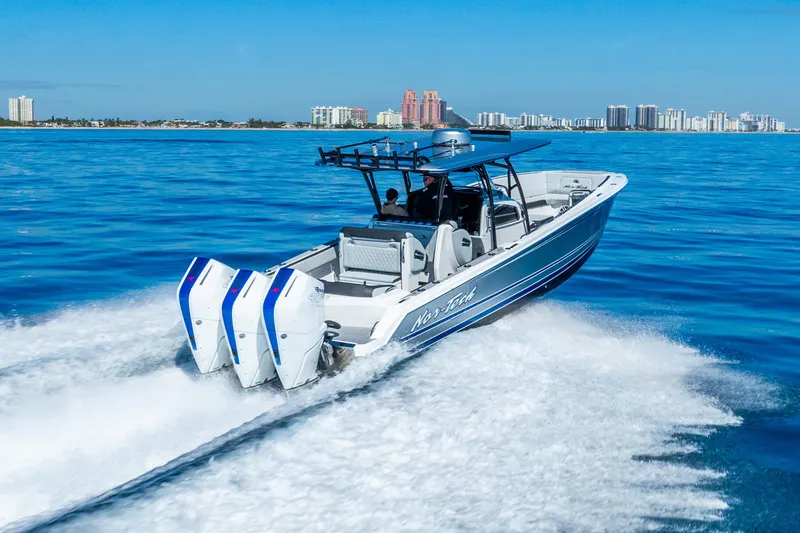 Slide: The Image of 2026 Nor-Tech 390 Sport Center Console cruising on blue ocean near city skyline. - 16