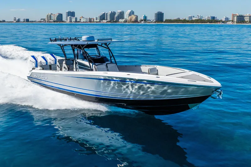 Slide: The Image of 2026 Nor-Tech 390 Sport Center Console cruising on blue ocean near city skyline. - 18