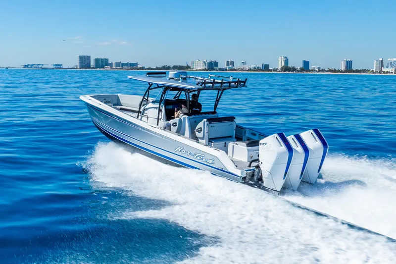 Slide: The Image of 2026 Nor-Tech 390 Sport Center Console cruising on blue ocean near city skyline. - 19