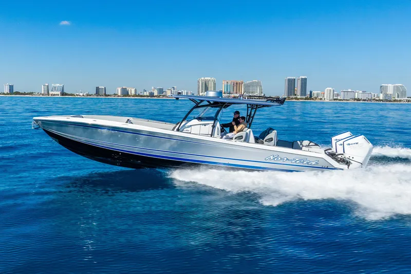 Slide: The Image of 2026 Nor-Tech 390 Sport Center Console cruising on blue ocean near city skyline. - 20