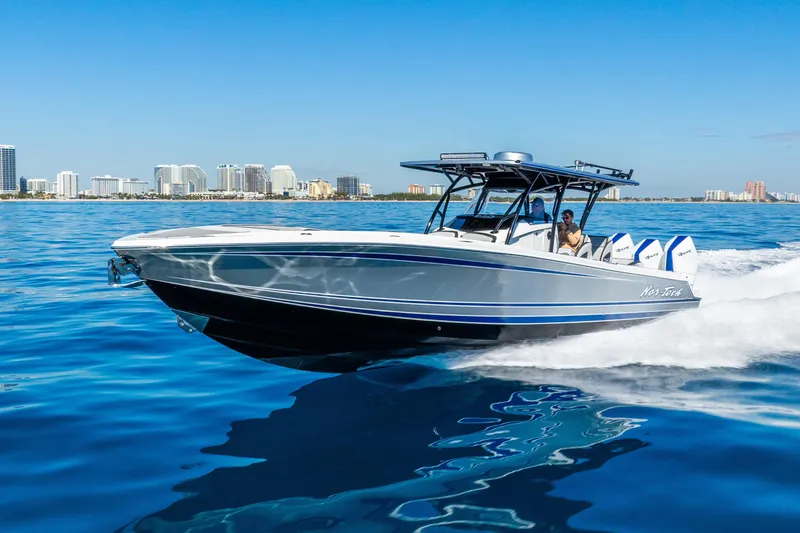 Slide: The Image of 2026 Nor-Tech 390 Sport Center Console cruising on blue ocean near city skyline. - 21