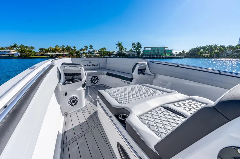 Slide: The Image of 2026 Nor-Tech 390 Sport Center Console boat interior with luxurious seating and waterfront view. - 23