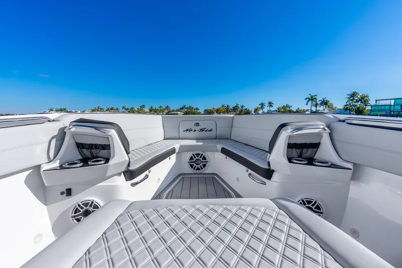 Slide: The Image of 2026 Nor-Tech 390 Sport Center Console boat interior with luxurious seating and cup holders. - 24