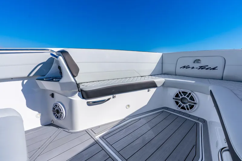 Slide: The Image of 2026 Nor-Tech 390 Sport Center Console boat interior with cushioned seating and speakers. - 25