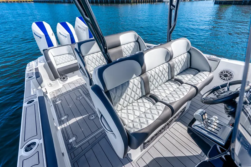 Slide: The Image of 2026 Nor-Tech 390 Sport Center Console boat interior with luxurious seating and triple engines. - 43