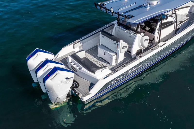Slide: The Image of 2026 Nor-Tech 390 Sport Center Console boat with triple outboard engines on water. - 5