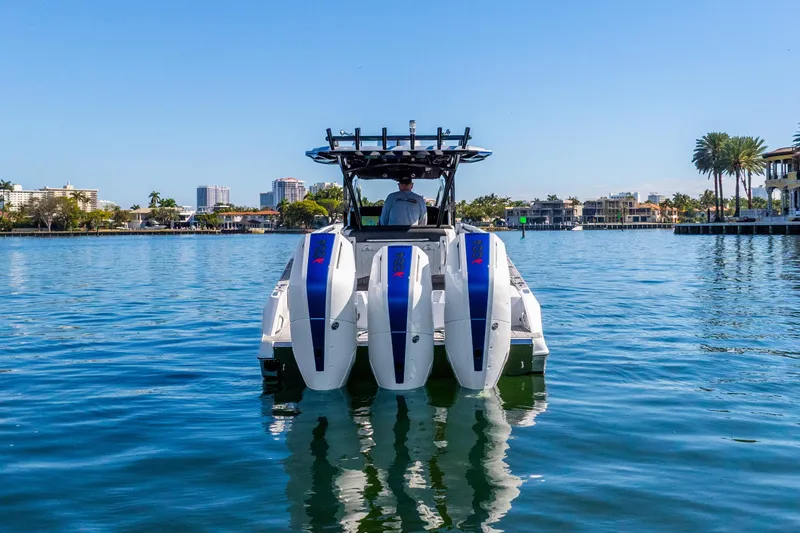 Slide: The Image of 2026 Nor-Tech 390 Sport Center Console boat on calm water, cityscape background. - 7