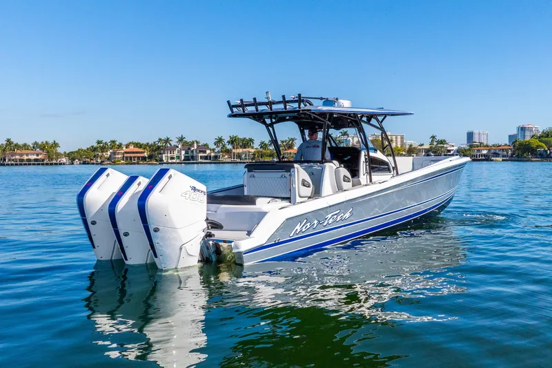 Slide: The Image of 2026 Nor-Tech 390 Sport Center Console boat on calm water, featuring triple engines. - 8