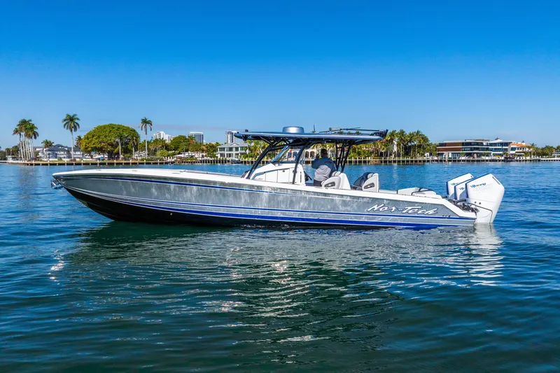 Slide: The Image of 2026 Nor-Tech 390 Sport Center Console boat cruising on a sunny day. - 9