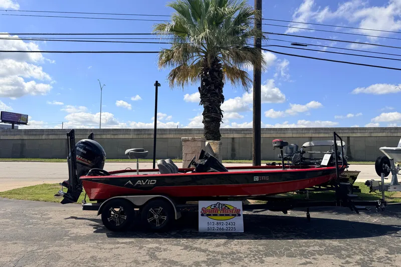 The Image of 2023 Avid 20 XB boat on trailer, parked outdoors under a clear blue sky. - 1