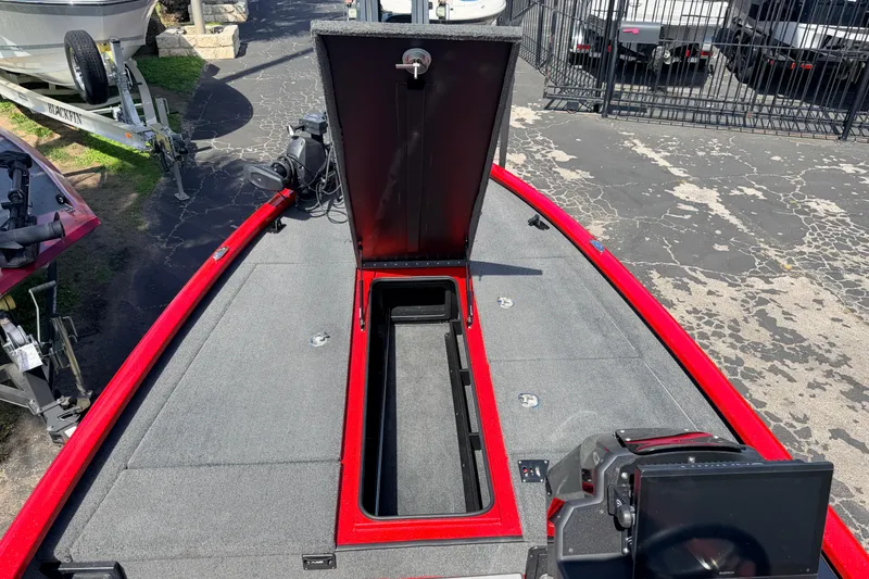 Slide: The Image of 2023 Avid 20 XB boat with open storage compartment, red trim, and modern dashboard. - 18