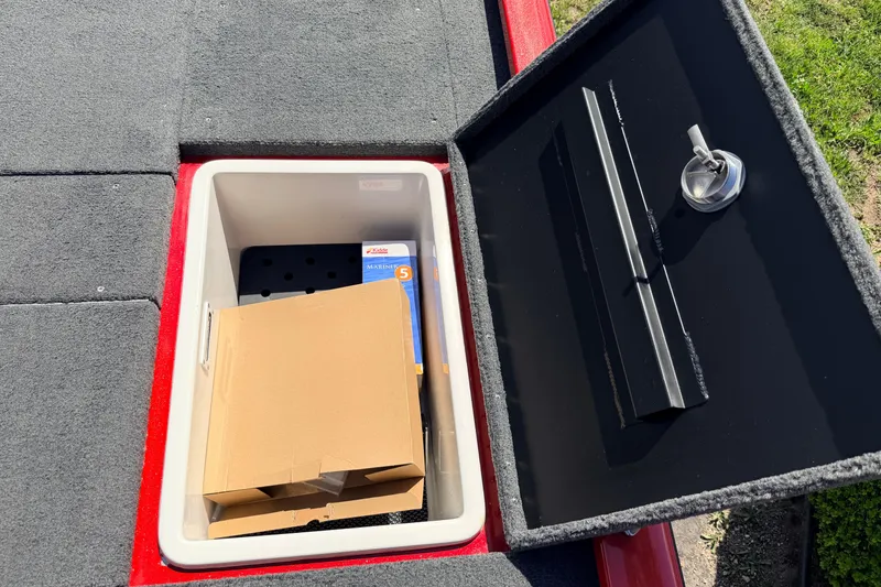 Slide: The Image of Storage compartment of 2023 Avid 20 XB boat with cardboard box and marine supplies. - 35
