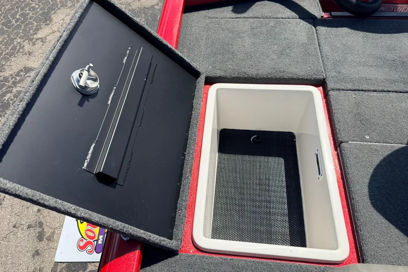 Slide: The Image of Open storage compartment in 2023 Avid 20 XB boat, featuring carpeted interior and secure latch. - 37