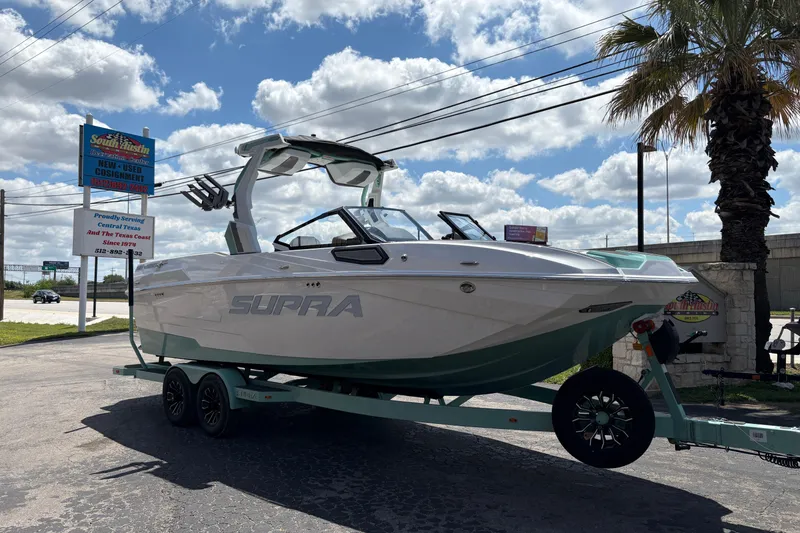 The Image of 2026 Supra SE 550 boat on trailer under a partly cloudy sky. - 1