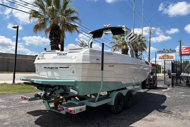 Slide: The Image of 2026 Supra SE 550 boat on trailer, parked outdoors under a clear blue sky. - 10