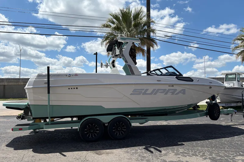 Slide: The Image of 2026 Supra SE 550 boat on trailer under blue sky with clouds. - 12