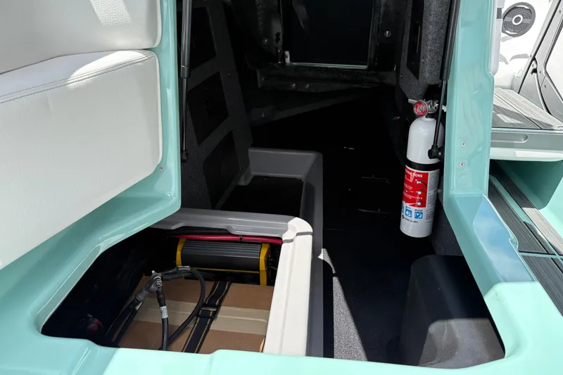 Slide: The Image of Interior view of 2026 Supra SE 550 boat storage compartment with fire extinguisher. - 43