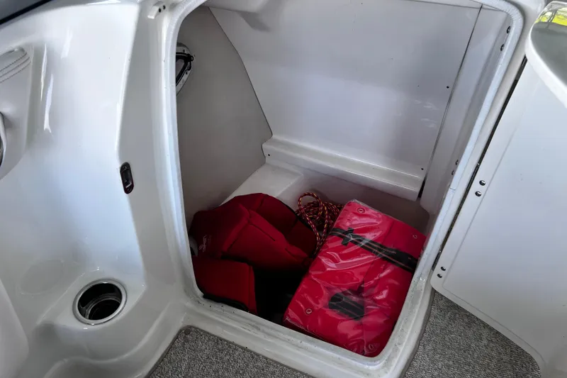 Slide: The Image of Storage compartment in a 2010 Chaparral Sunesta 224 boat with life jackets and rope. - 10