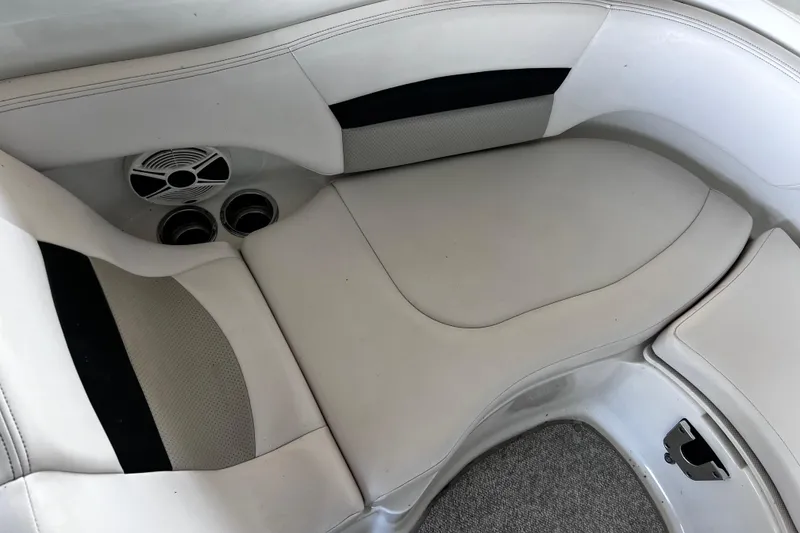 Slide: The Image of 2010 Chaparral Sunesta 224 boat interior with white seating and built-in speakers. - 13