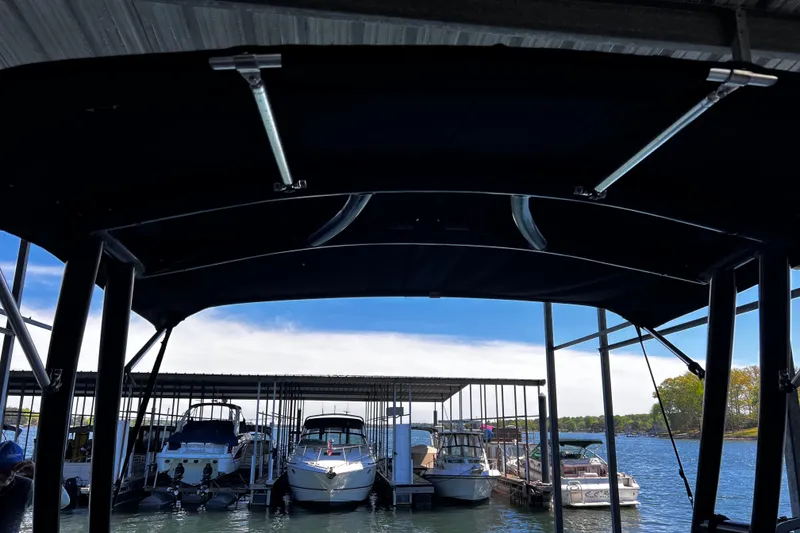 Slide: The Image of 2010 Chaparral Sunesta 224 docked under canopy with other boats on a sunny day. - 15