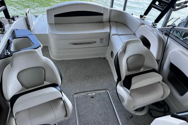 Slide: The Image of 2010 Chaparral Sunesta 224 boat interior with plush seating and lake view. - 16