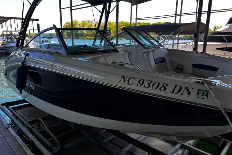 Slide: The Image of 2010 Chaparral Sunesta 224 boat docked, featuring sleek design and comfortable seating. - 2