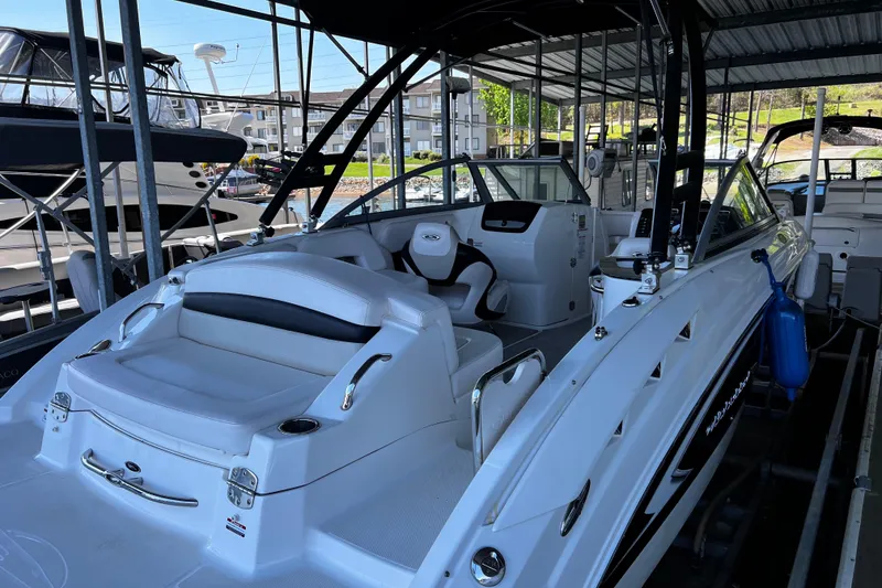 Slide: The Image of 2010 Chaparral Sunesta 224 boat docked, featuring sleek white design and spacious seating. - 3