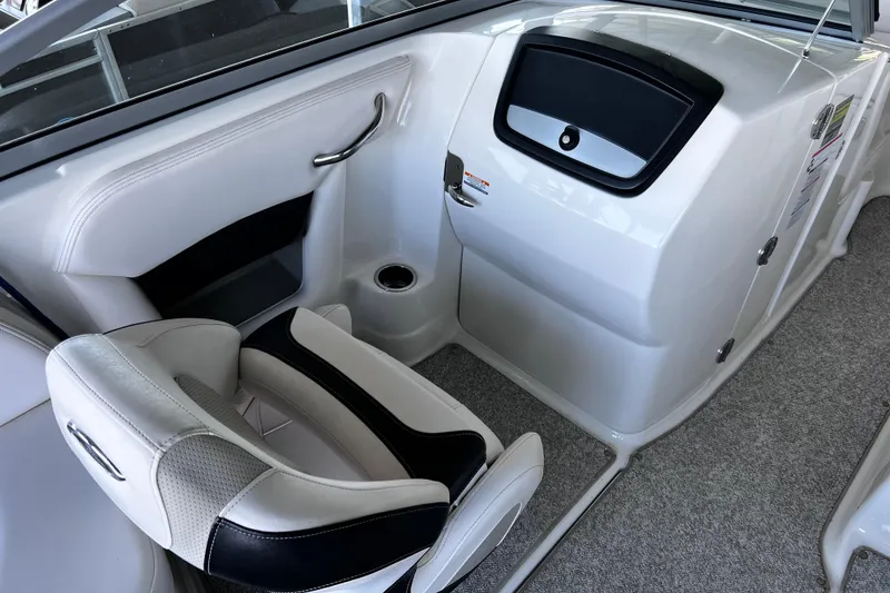 Slide: The Image of 2010 Chaparral Sunesta 224 boat interior with white seating and storage compartment. - 9