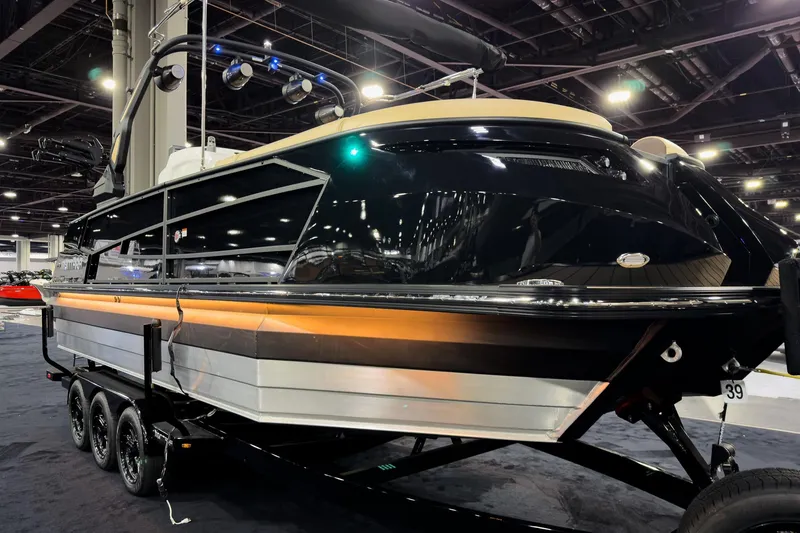 Slide: The Image of 2026 Montara Surf Boss EVO SLDH 25' boat displayed indoors on a trailer. - 10