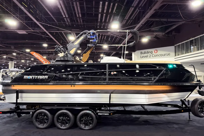 Slide: The Image of 2026 Montara Surf Boss EVO SLDH 25' boat displayed indoors on a trailer. - 11