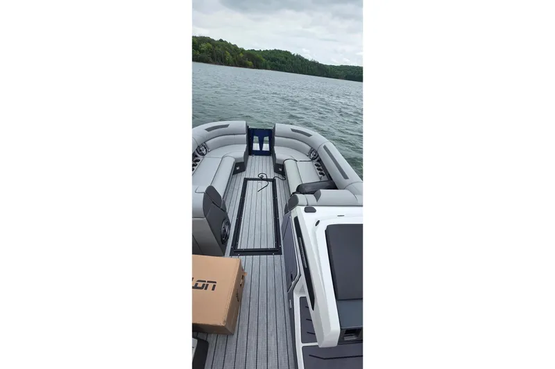 Slide: The Image of 2026 Montara Surf Boss EVO SLDH 25' boat interior on a lake with lush shoreline. - 6