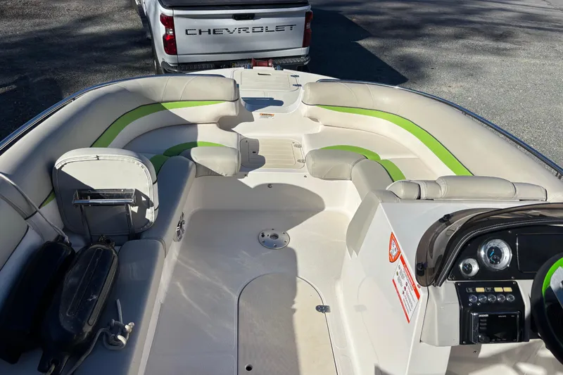 Slide: The Image of 2018 Starcraft Star Step 221 I/O boat interior with green accents, parked near a Chevrolet truck. - 2
