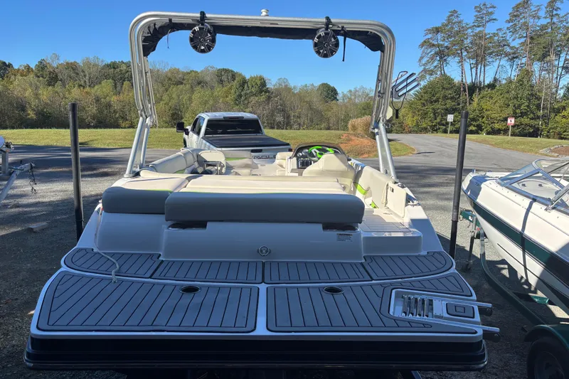 Slide: The Image of 2018 Starcraft Star Step 221 I/O boat with sleek deck and seating, parked outdoors. - 4