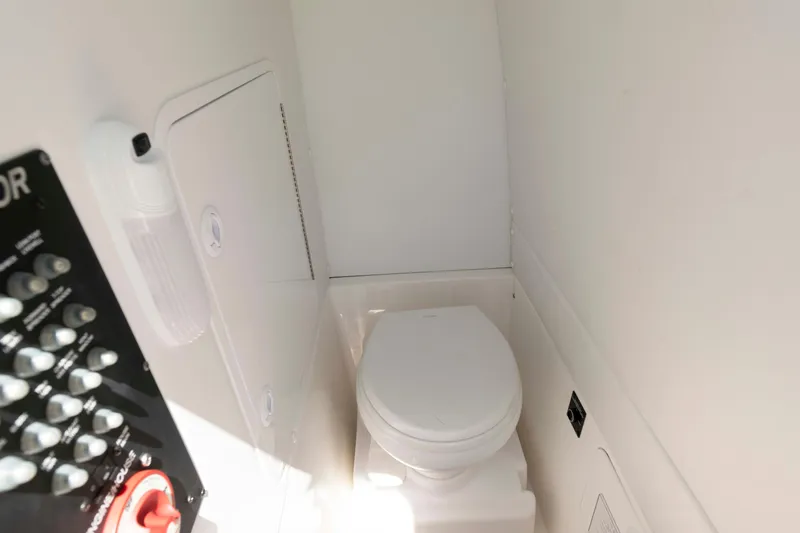 Slide: The Image of 2021 Regulator 26XO boat interior with compact marine toilet and control panel. - 25