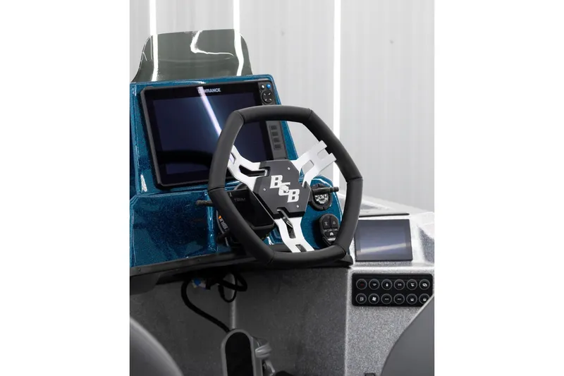 Slide: The Image of 2027 Bass Cat Pantera boat dashboard with steering wheel and digital display. - 2