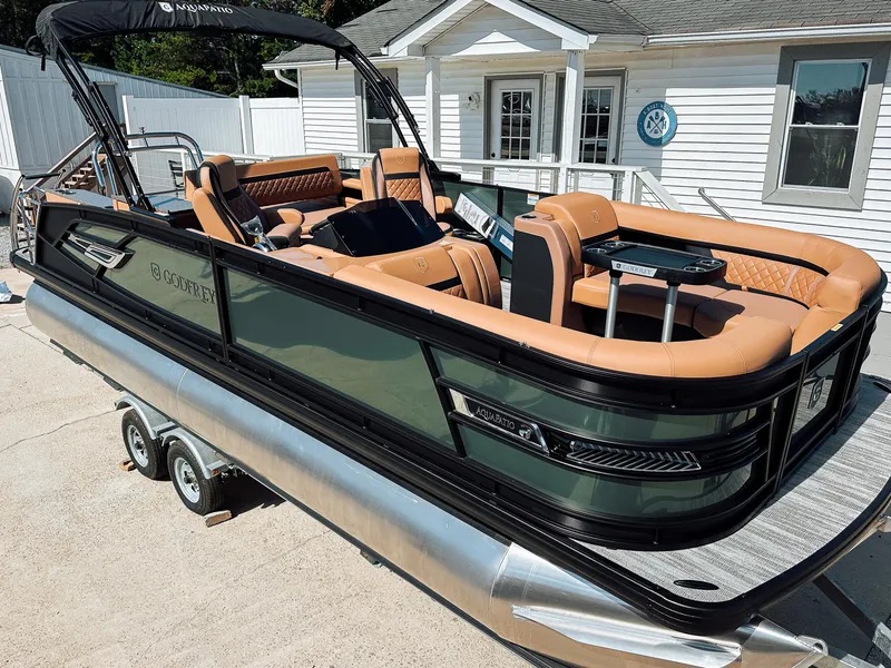 Slide: The Image of 2025 Godfrey AquaPatio 23' Flip Lounge Tritoon boat with luxurious seating and sleek design. - 2