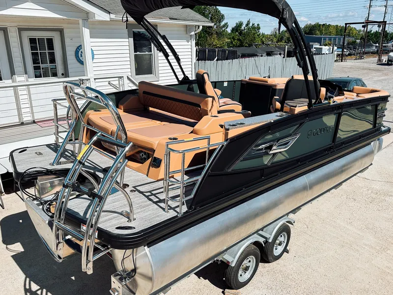 Slide: The Image of 2025 Godfrey AquaPatio 23' Flip Lounge Tritoon on trailer, featuring luxurious seating and sleek design. - 3